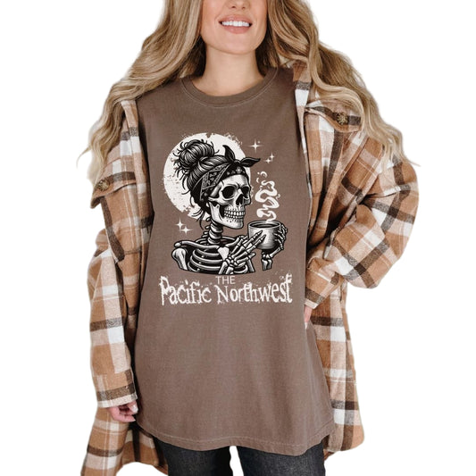 A person wearing a blue vintage-style tee with a graphic of a skull holding a mug and the text 'PACIFIC NORTHWEST'.