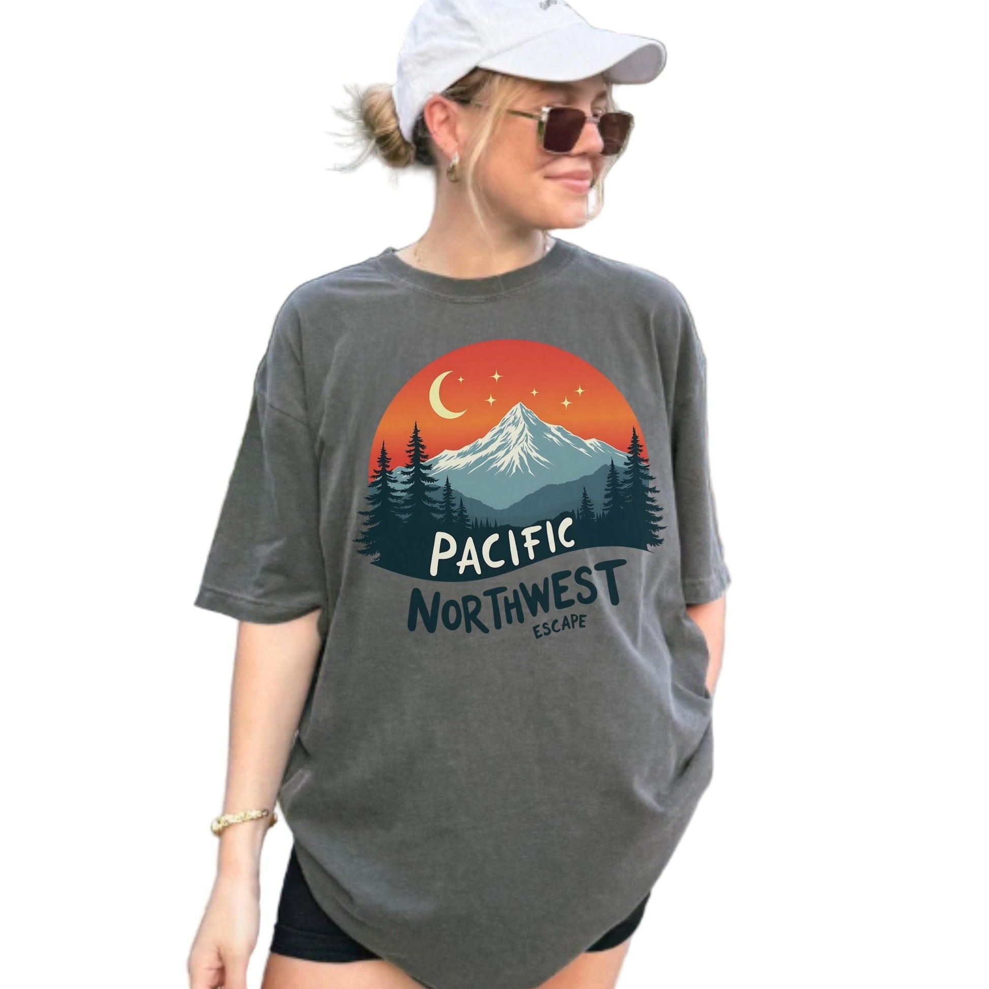 Woman wearing a gray t-shirt with a Pacific Northwest design outdoors.