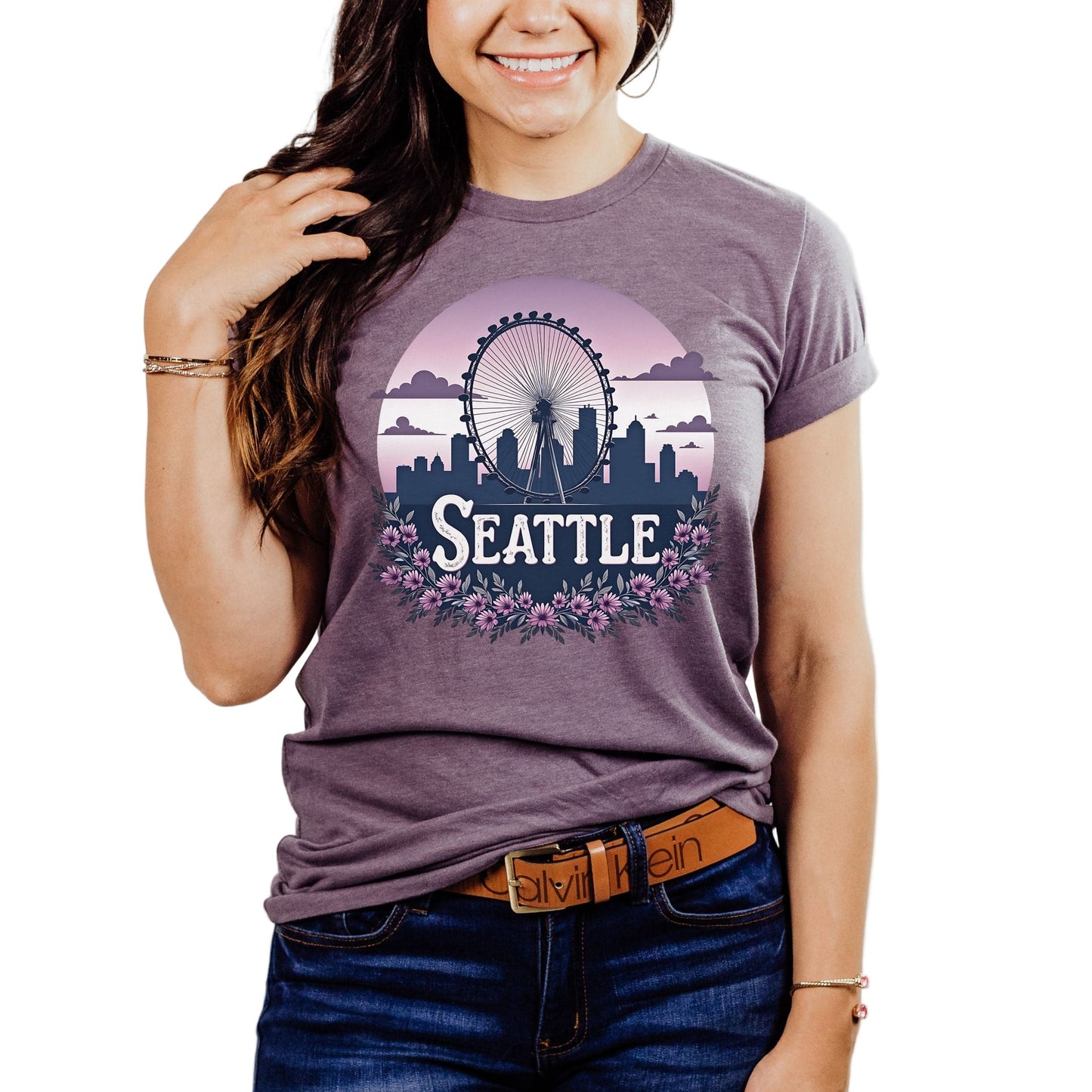 Person wearing a purple t-shirt with 'Seattle' design on a plain background